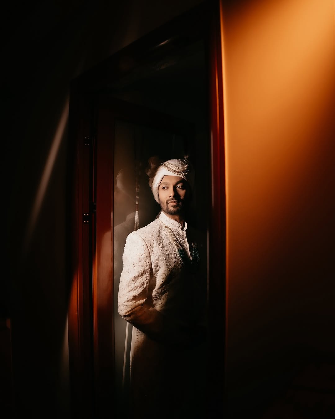 Groom in dramatic doorway light