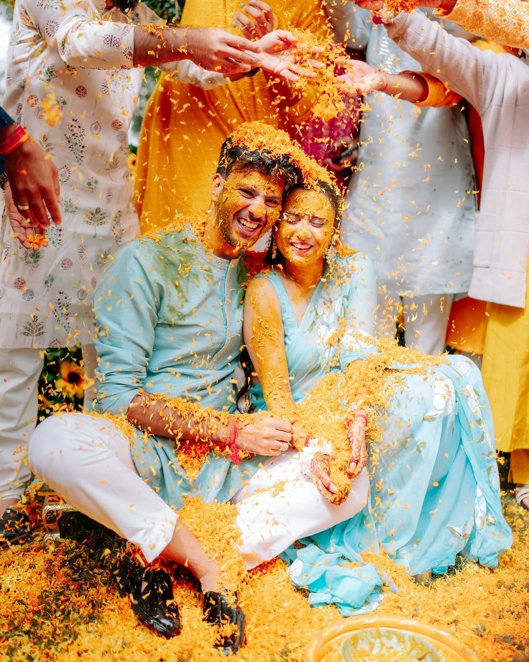 Couple covered in petals during haldi
